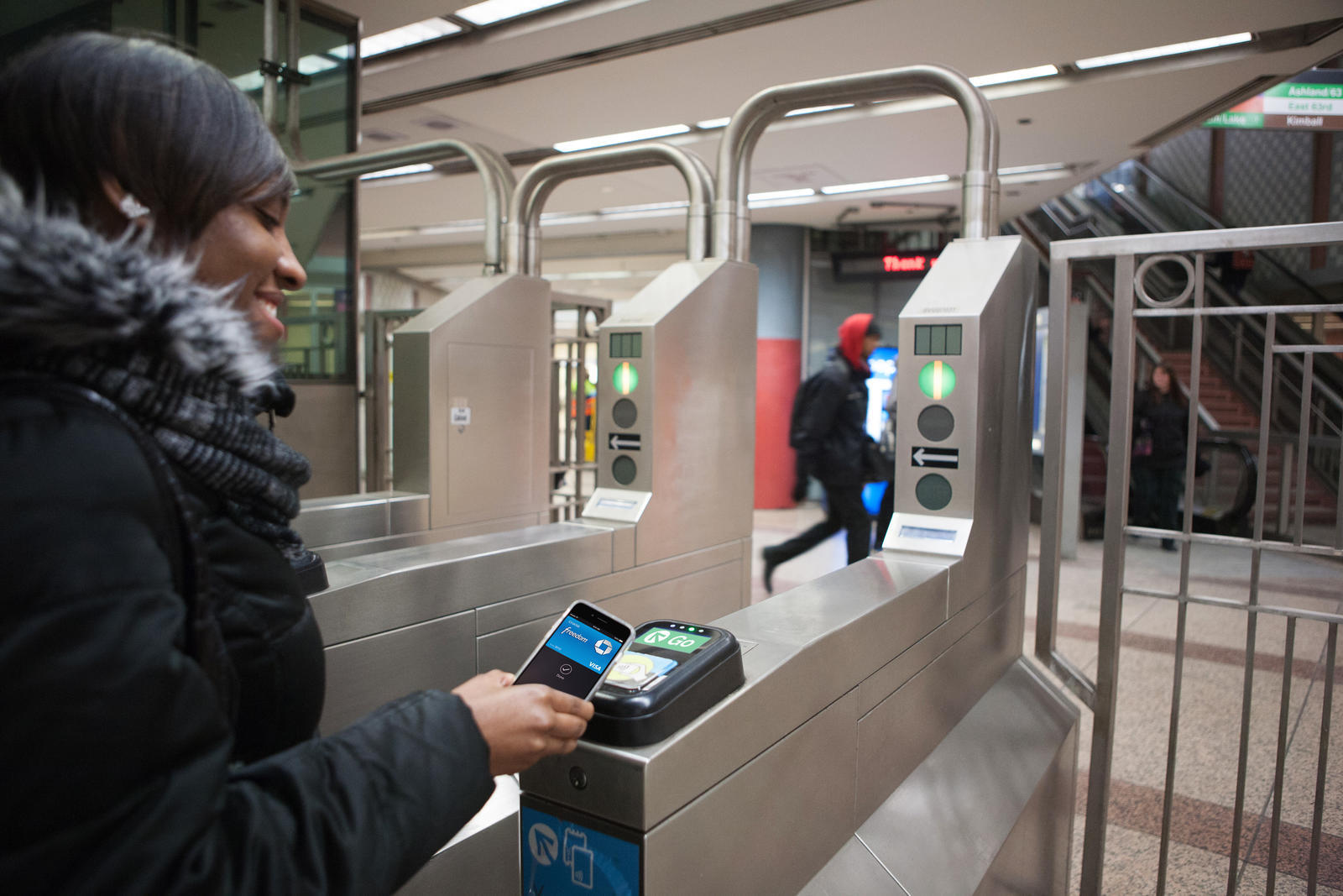 Women using Apple Pay on Cubic's Ventra Contactless Payment System to get on Bus